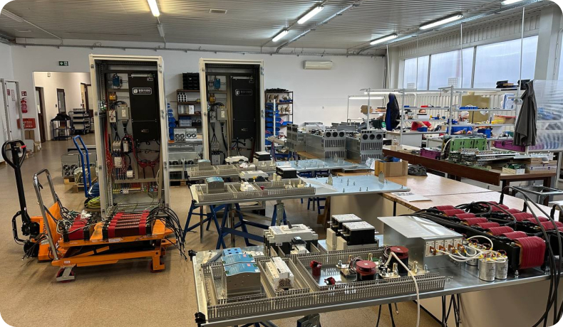 Vista panorámica del taller de ensamblaje industrial con componentes y bancos de trabajo para variadores de frecuencia TWERD