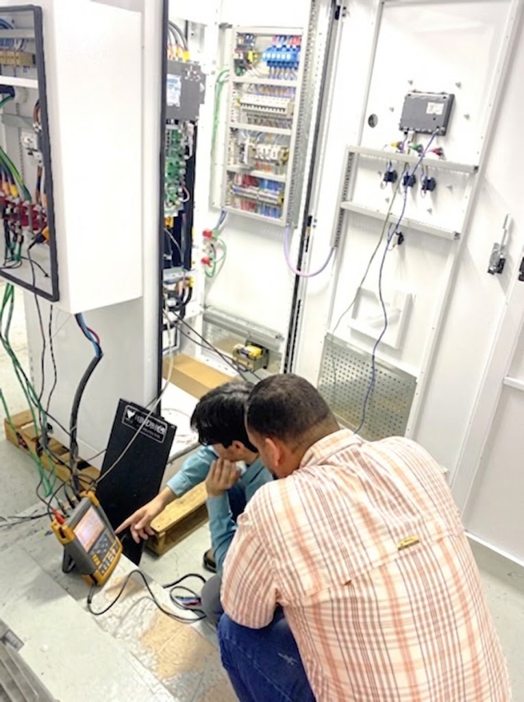 Técnicos de Gramler Drives realizando pruebas en banco de prueba de un variador TWERD en un tablero eléctrico